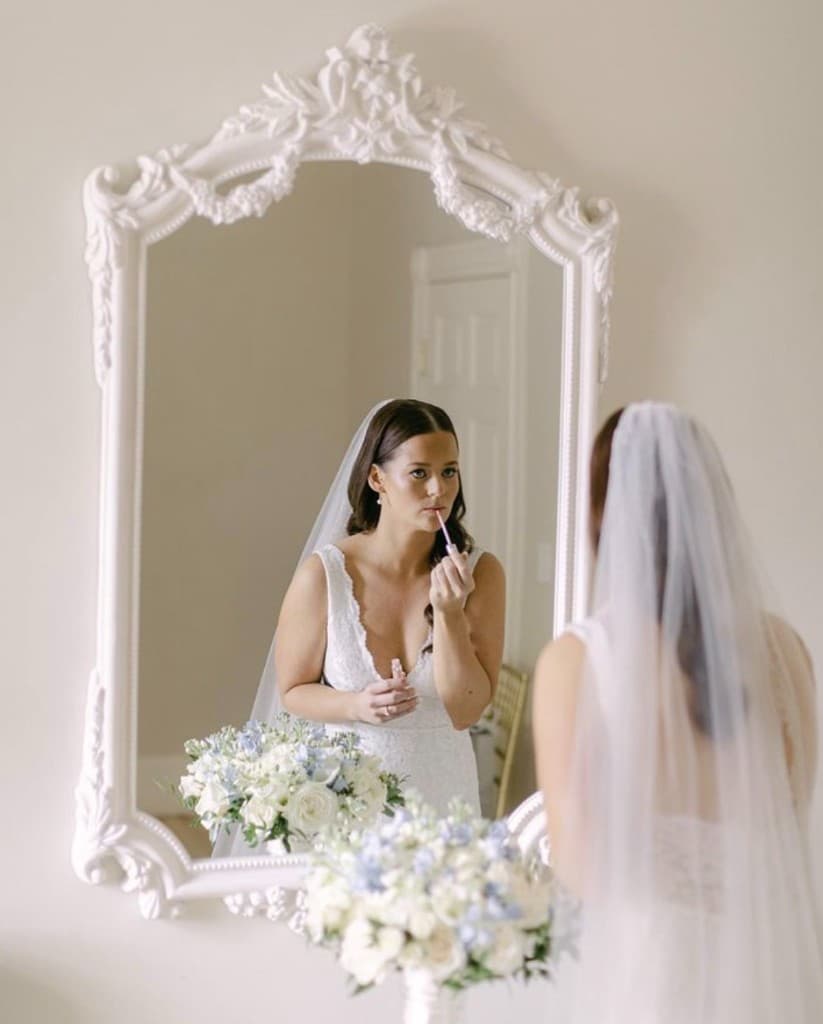 Bride looking in mirror while getting ready