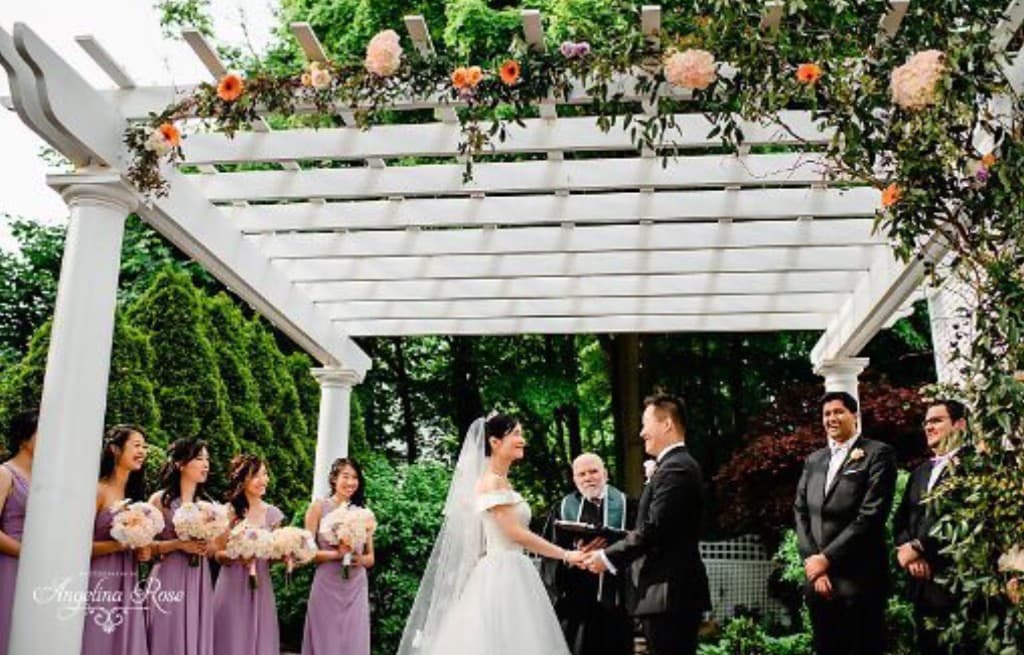 Ceremony under pergola with lavender and wedding party