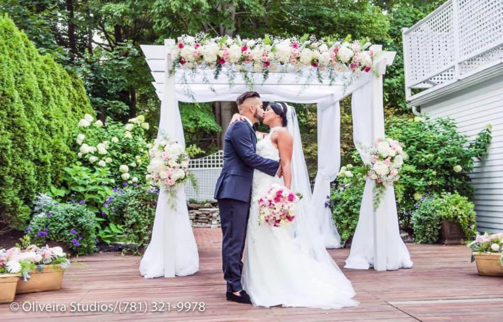 Couple kissing under pergola with drapes