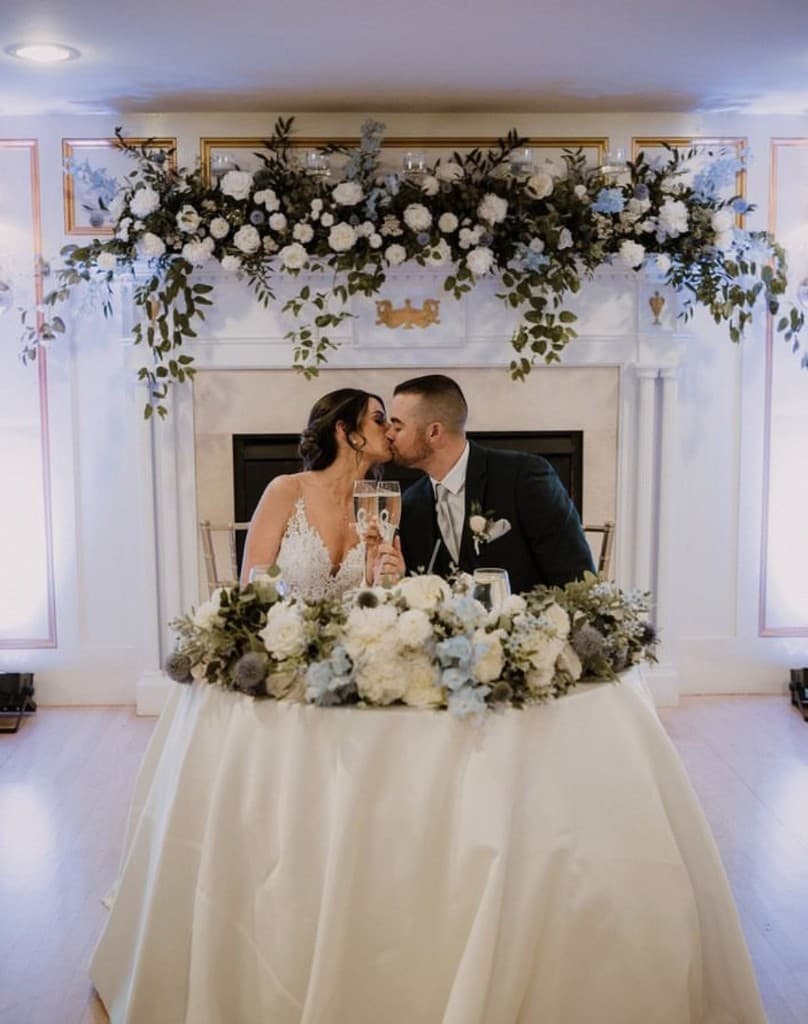 Couple kissing at sweetheart table