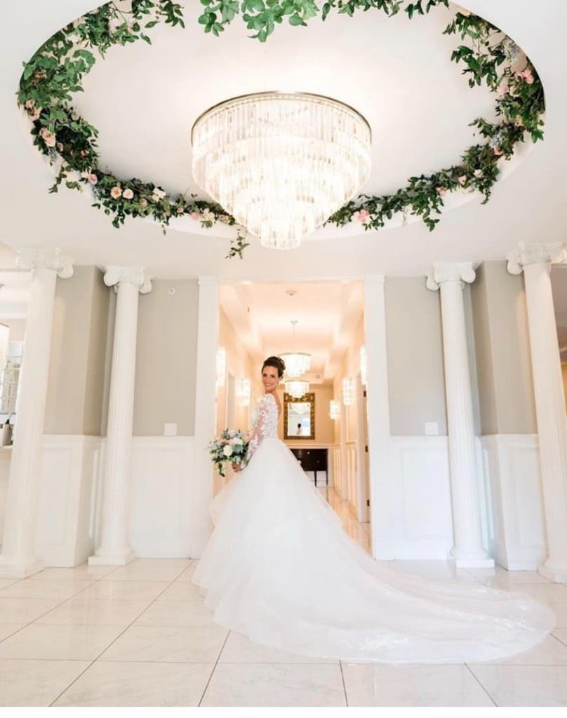 Bride in rotunda beneath crystal chandelier
