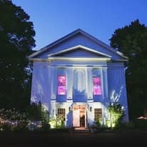 The Commons 1854 building at twilight with uplighting